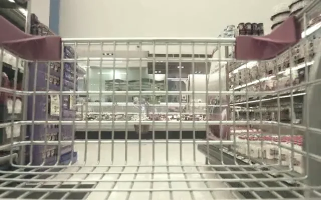 Corsia di un supermercato vista da dietro un carrello